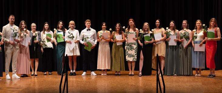 Diplomandinnen und Diplomanden an der Diplomfeier mit Blumen und ihrem Diplom in der Hand