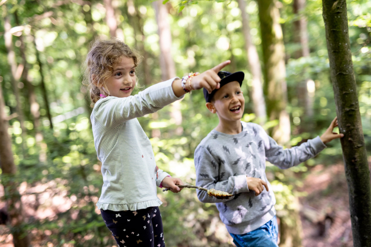 Ein Mädchen und ein Junge, die gemeinsam im Wald spielen
